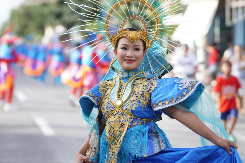 a beautiful young woman wearing blue dress and a colorful headpiece