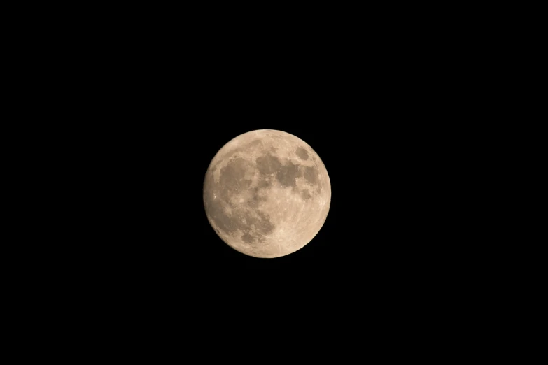 an almost full moon seen in the black night sky