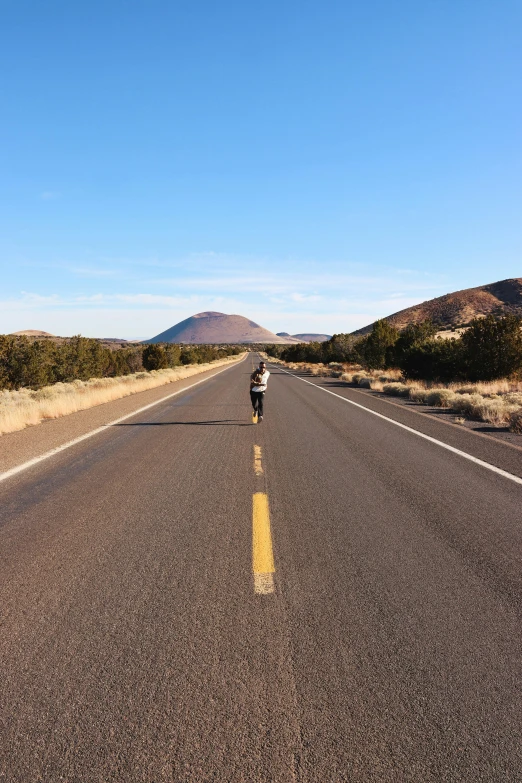 a person riding a bike down a deserted road