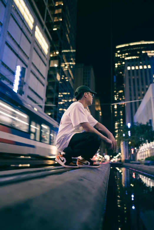 a boy sitting on the edge of a street at night