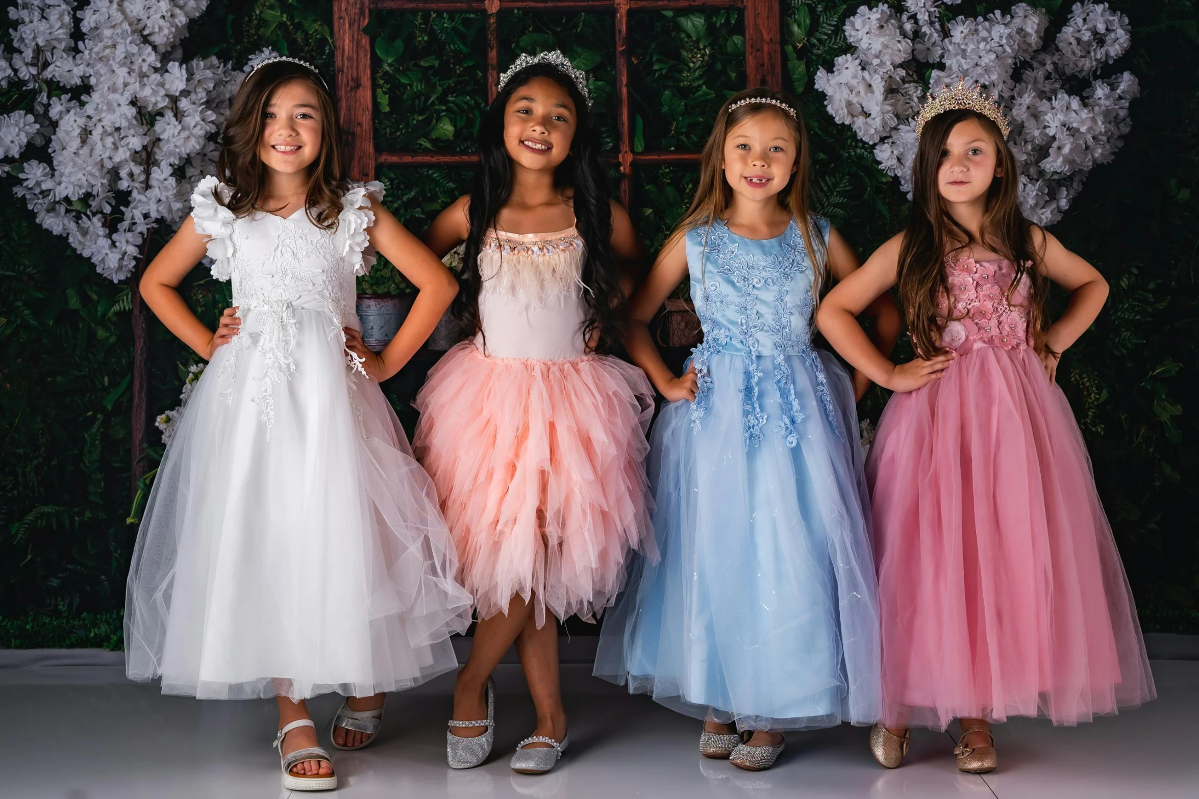 the four little girls are posing in their dresses