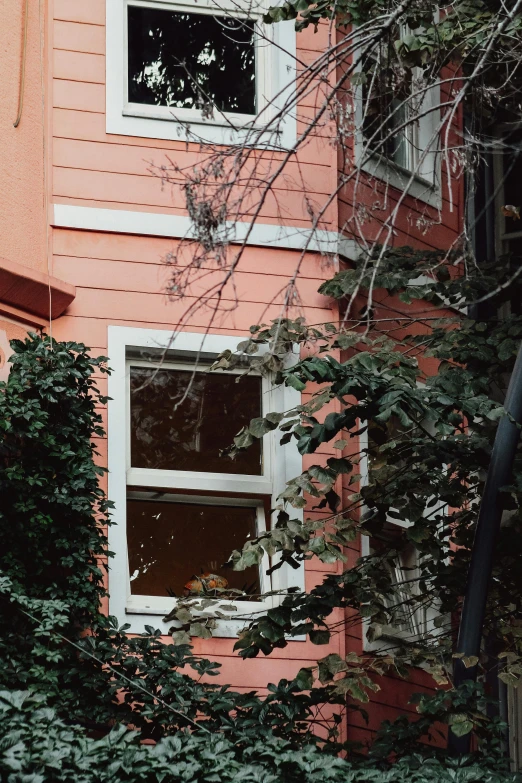 an orange building with a small window and a red facade