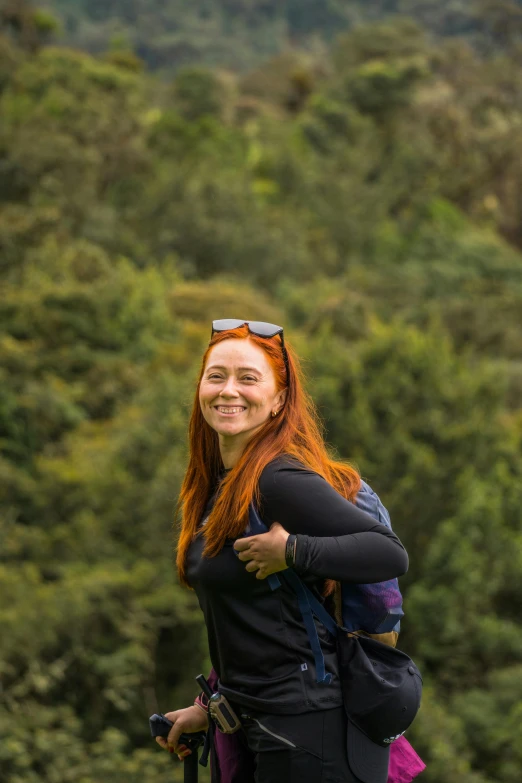 a woman walking with a large backpack and trees