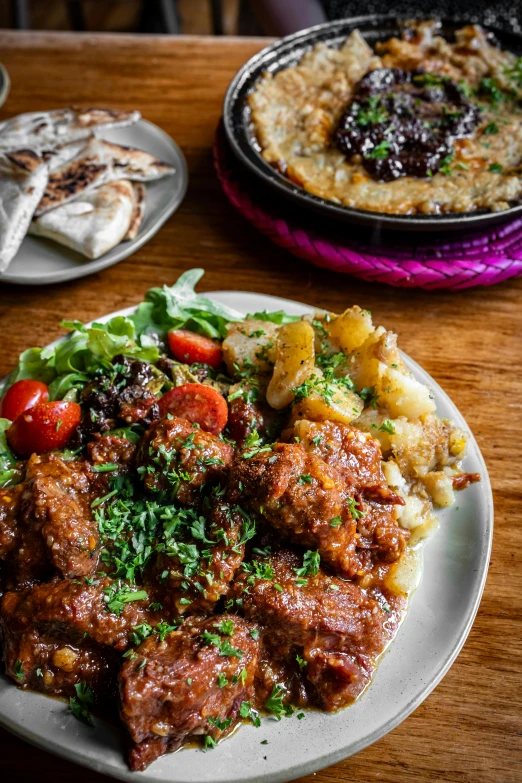 a white plate filled with meatballs, potatoes and vegetables