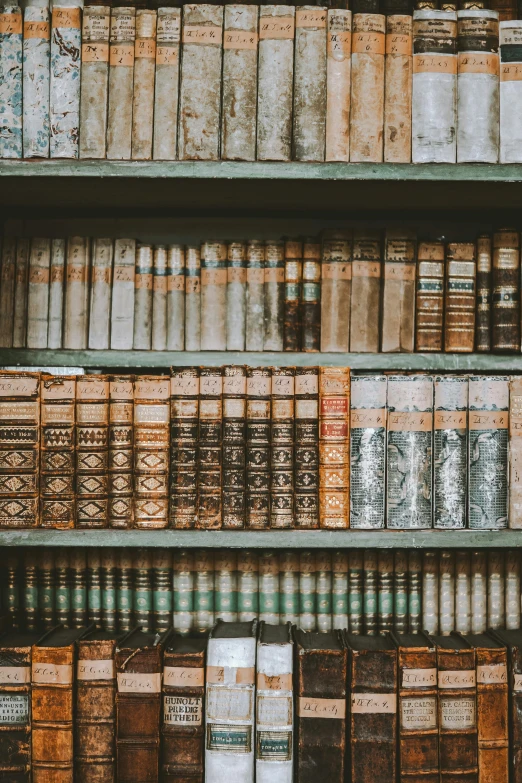 a collection of old books that are stacked on shelves