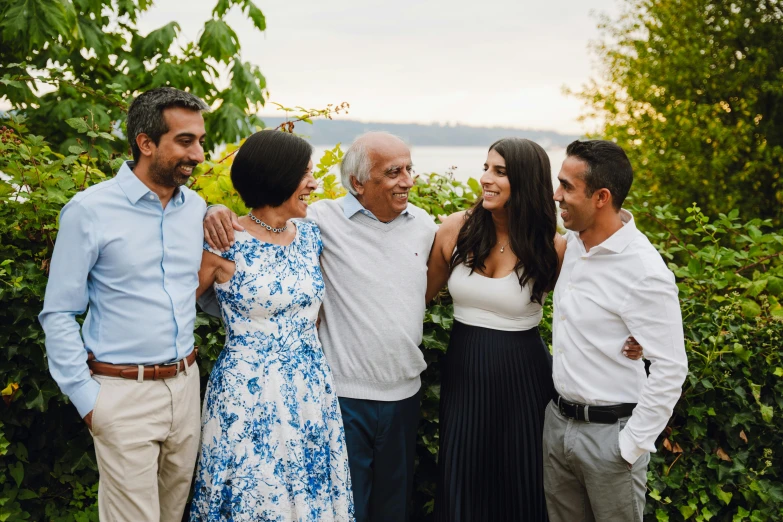 an older man and two women smiling as they stand with two younger men