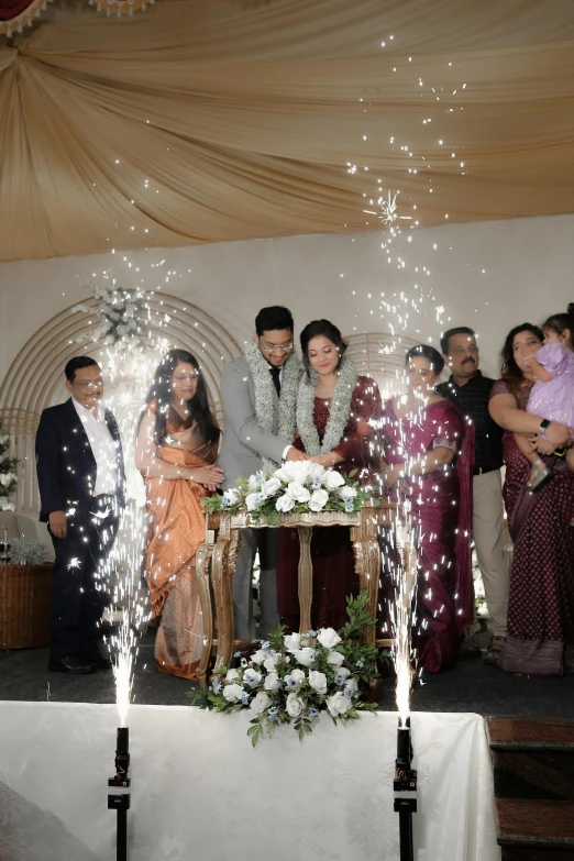 several people with white flowers are standing near a bride and groom