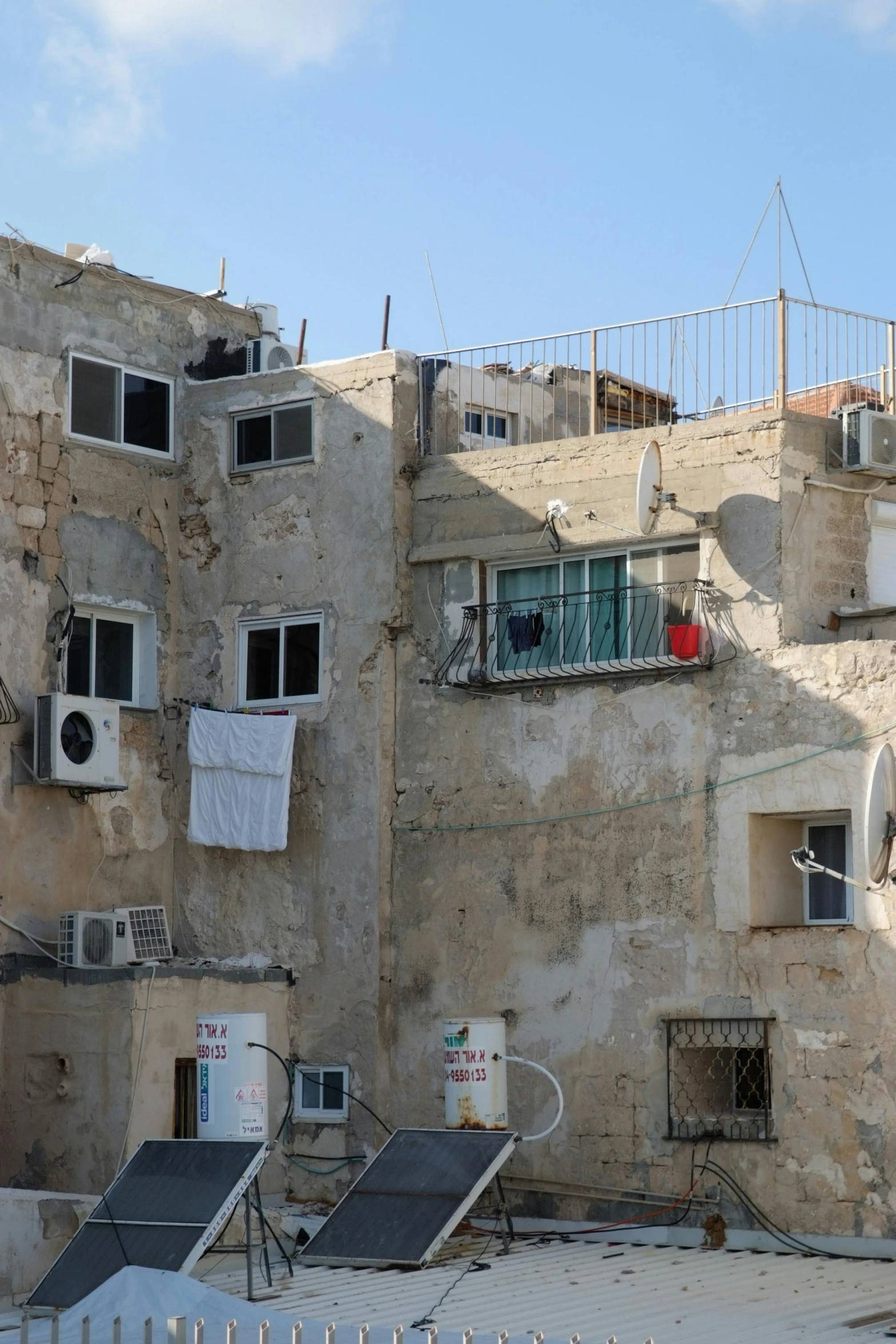 a very old and rusty looking building with clothes drying on the clothesline