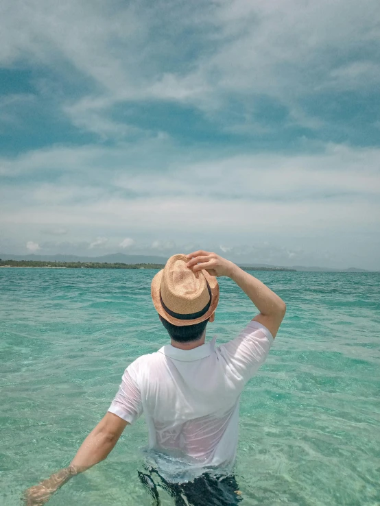 a man standing in clear water looking to the sky