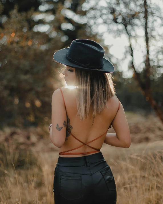 a woman wearing a hat is walking in the middle of the woods