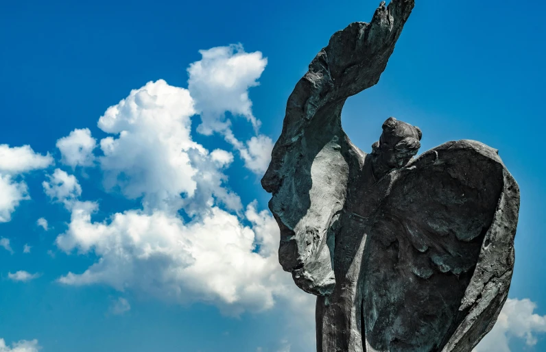 a statue of a winged bird on a bright day