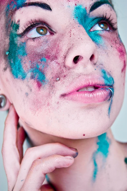 a young woman is smeared with colors from blue and red