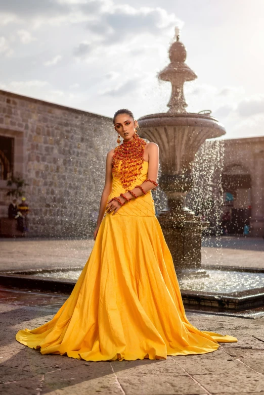 a woman wearing a bright yellow dress with her hands crossed