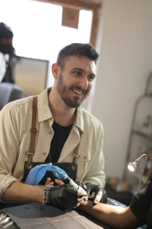 the man with the apron is wearing gloves and working