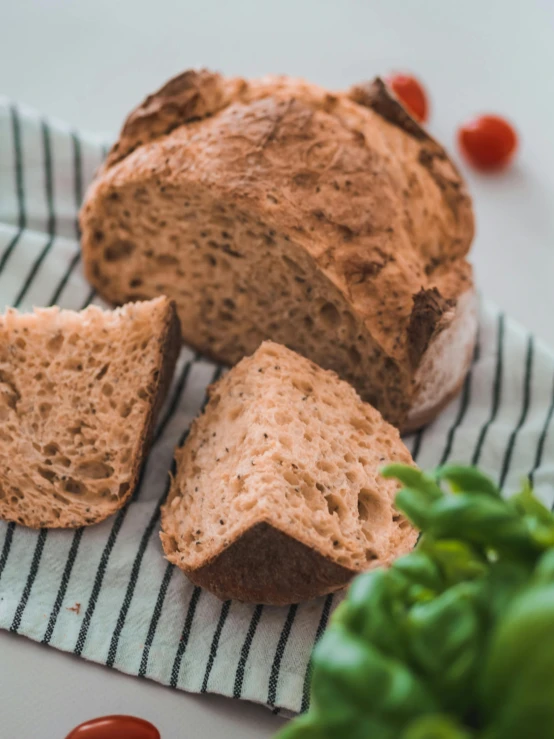 a loaf of bread is sliced on top of a towel