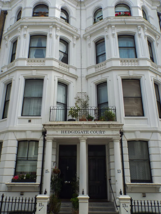 a big white building with flowers outside the front