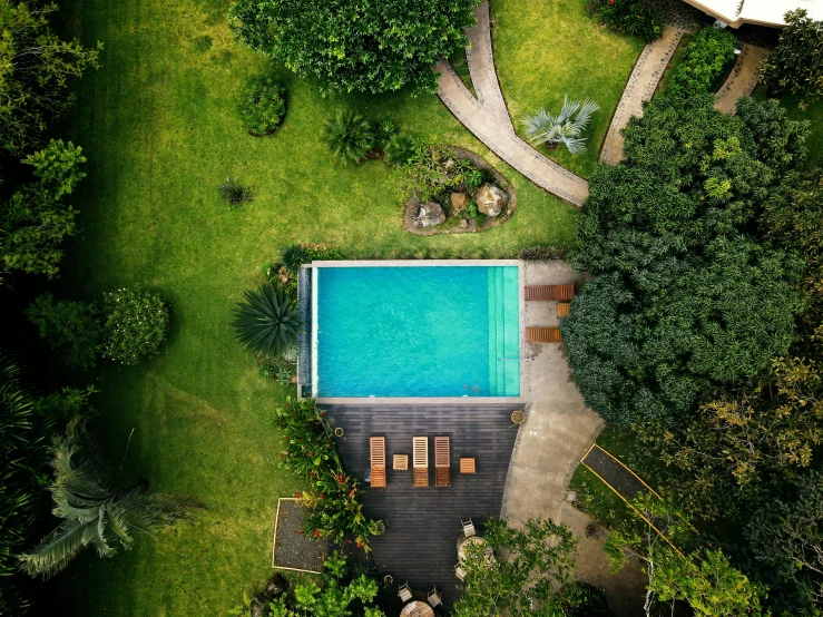 an aerial view of the back yard, pool, and deck of a home