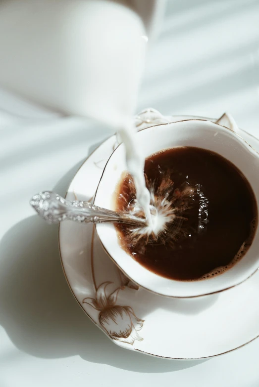 sauce being poured into the inside of a cup