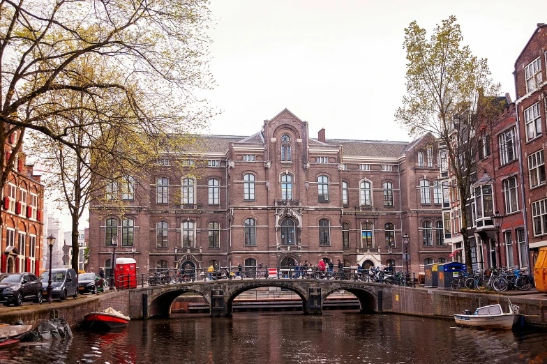 people riding bicycles on the sidewalk around a canal