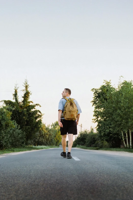 a man on the road with a backpack on his back