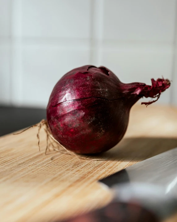 there is a knife and an onion on the board