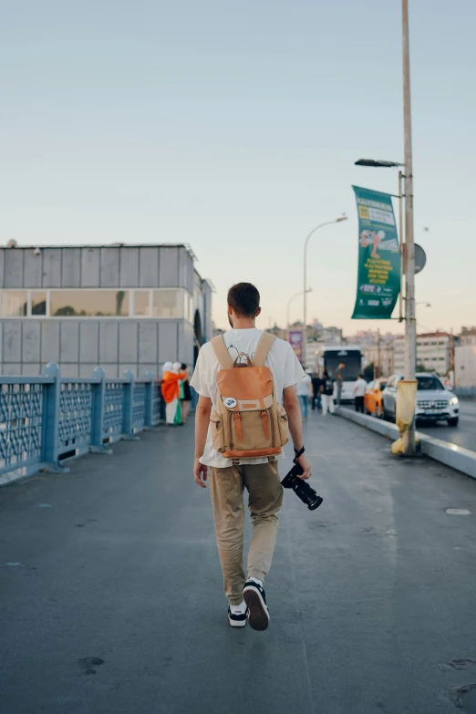 a man walking across a street holding a camera