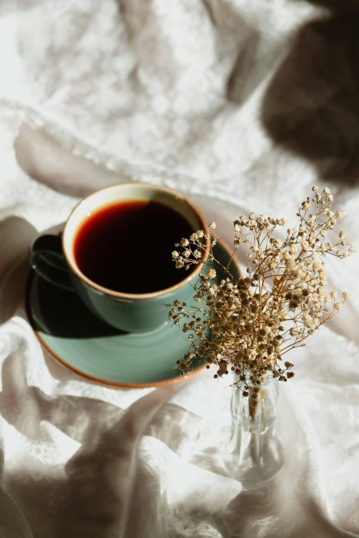 a mug with some flowers in it on top of a table