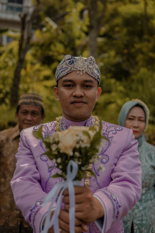 the man in purple is placing flowers on his face