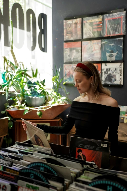 a woman sitting at a counter in a store reading a newspaper