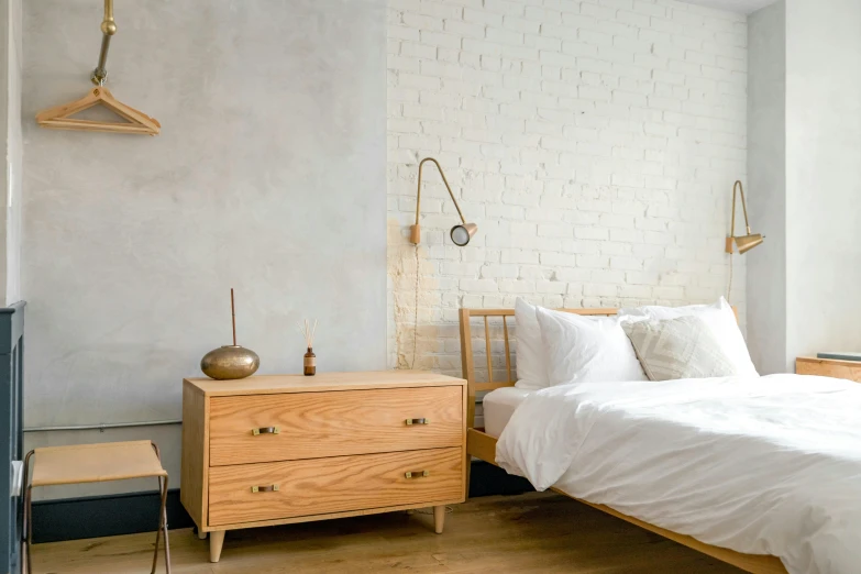an old white bedroom is furnished with a modern dresser