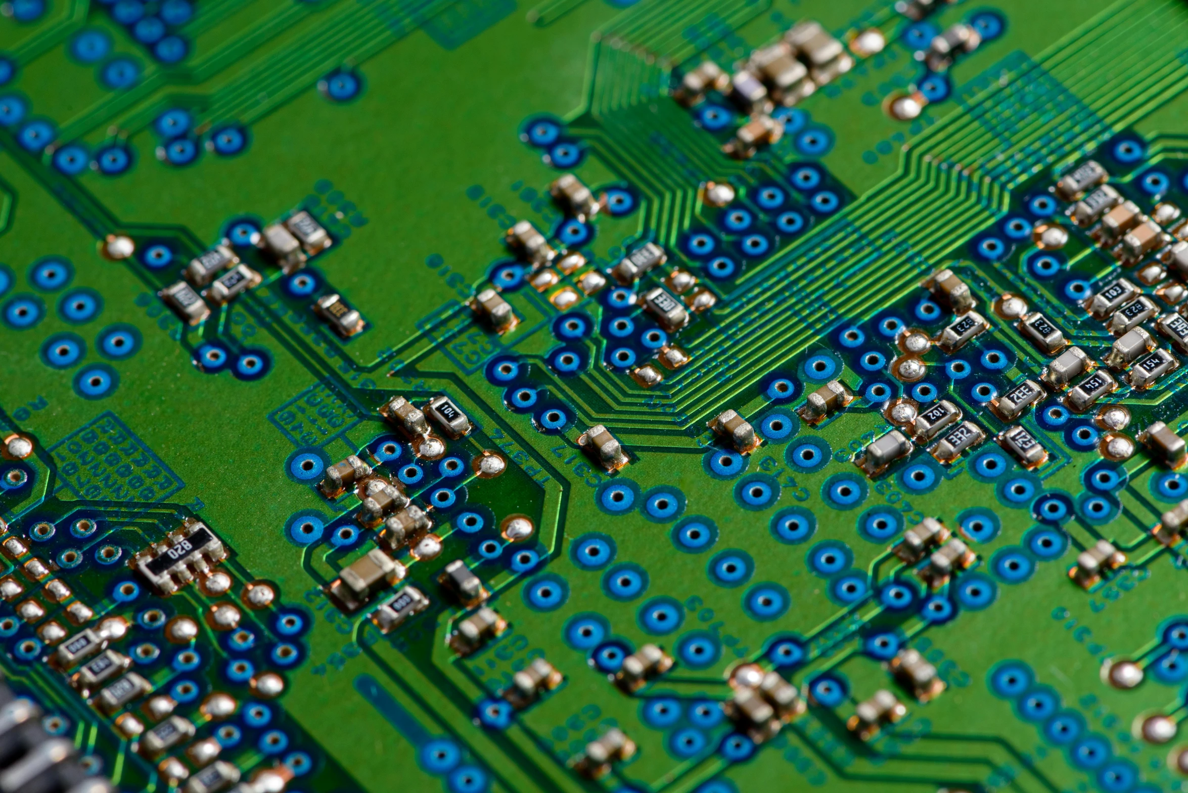 closeup of a green electronic board with lots of blue dots