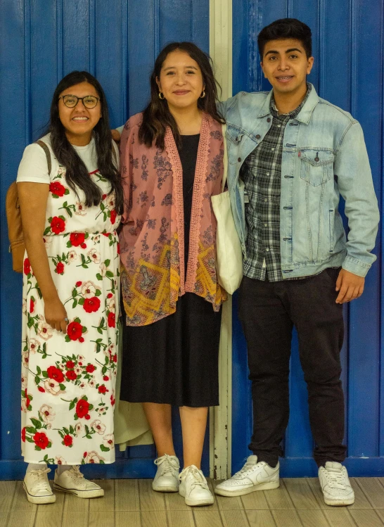 three people standing in front of a wall