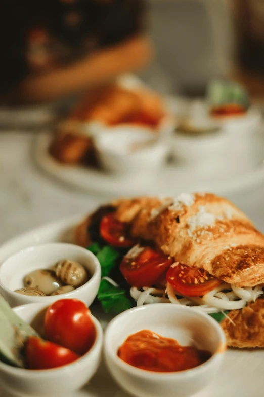 two bowls of soup and bread on a white plate