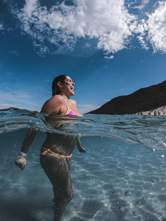 a woman is swimming in the water near the shore