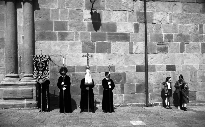 black and white image of four people in robes standing