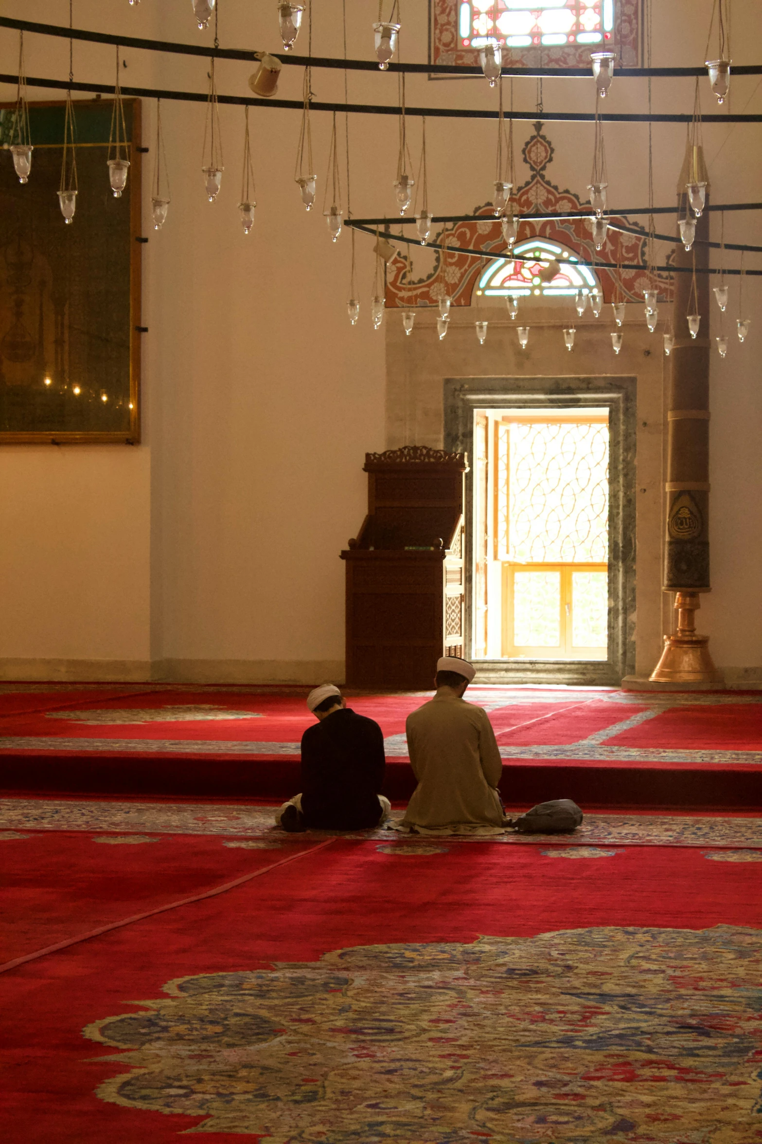 two men sitting on the ground in a building