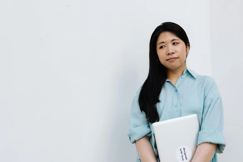 a woman in a blue shirt is holding her folder