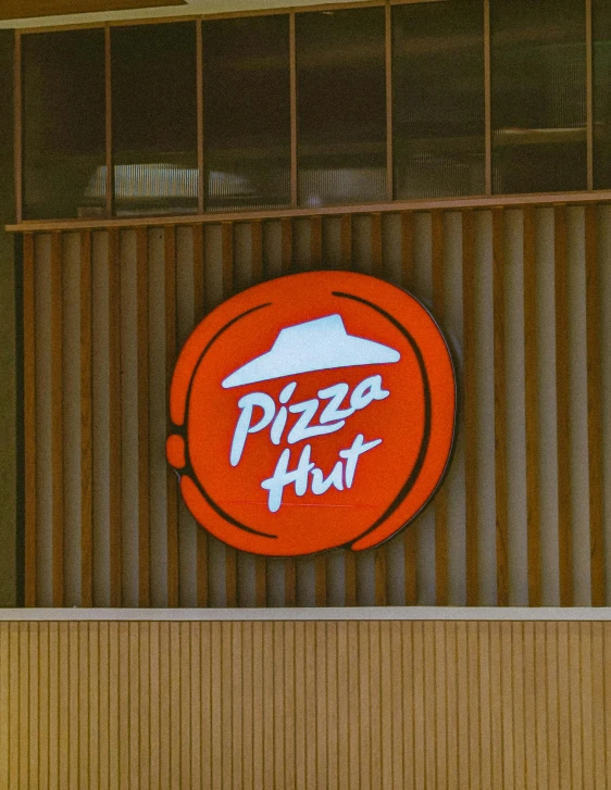 a pizza hut sign above a wooden building