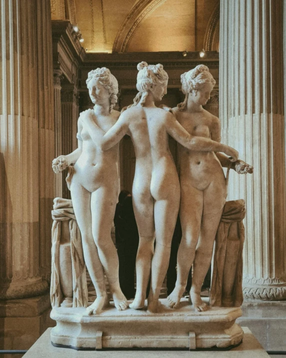 three  women on pedestals standing inside a building