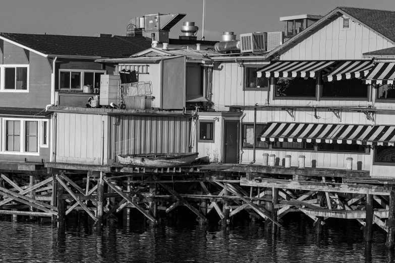 a black and white po of a house on stilts over water