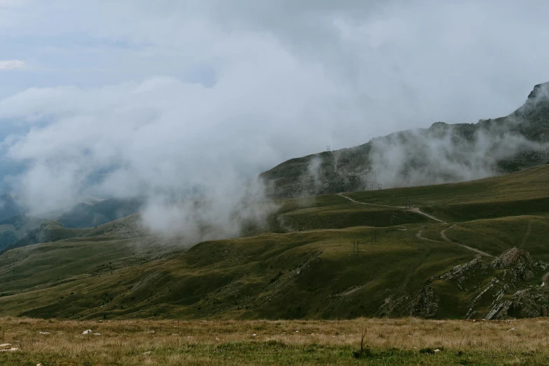 a lone horse grazes on an open mountain side