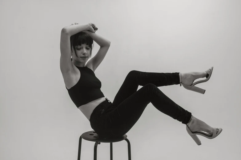 a woman sitting on top of a stool