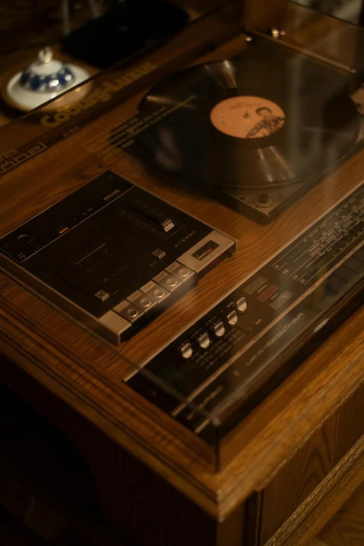 a wooden table with some record player and a vinyl album