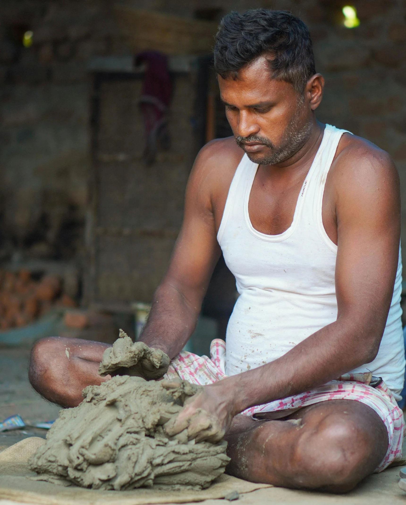 a man is making clay art in his home