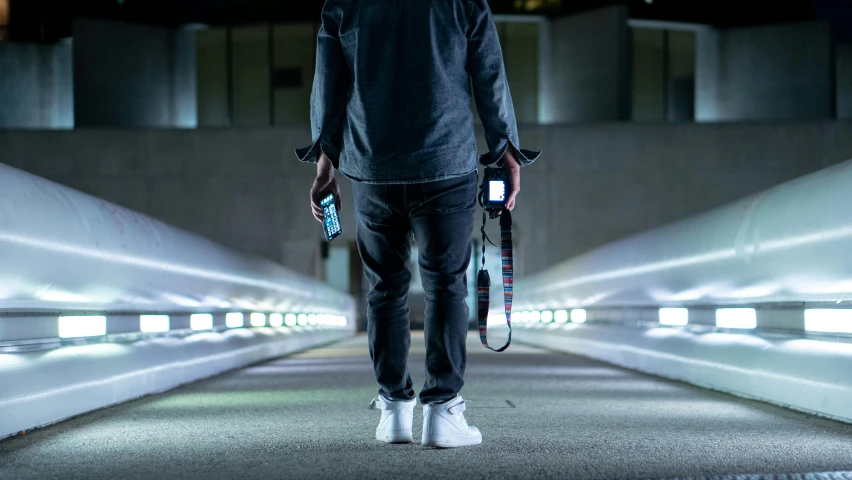 a man with headphones and a leash walks down a walkway