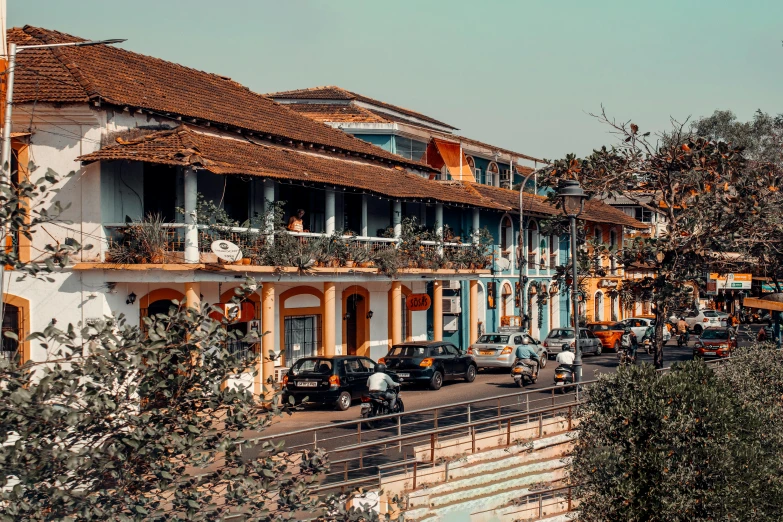 cars driving by a row of houses with balconies