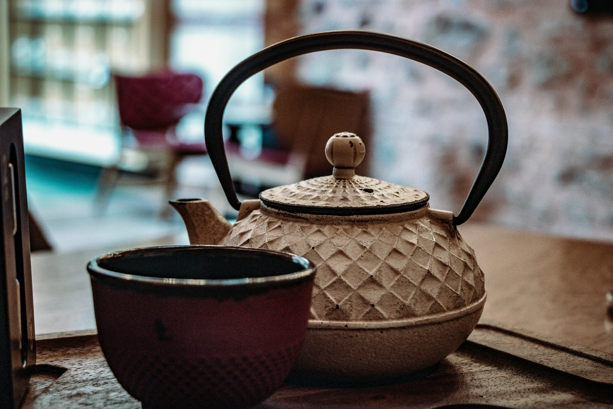 a tea pot and coffee cup on top of a table