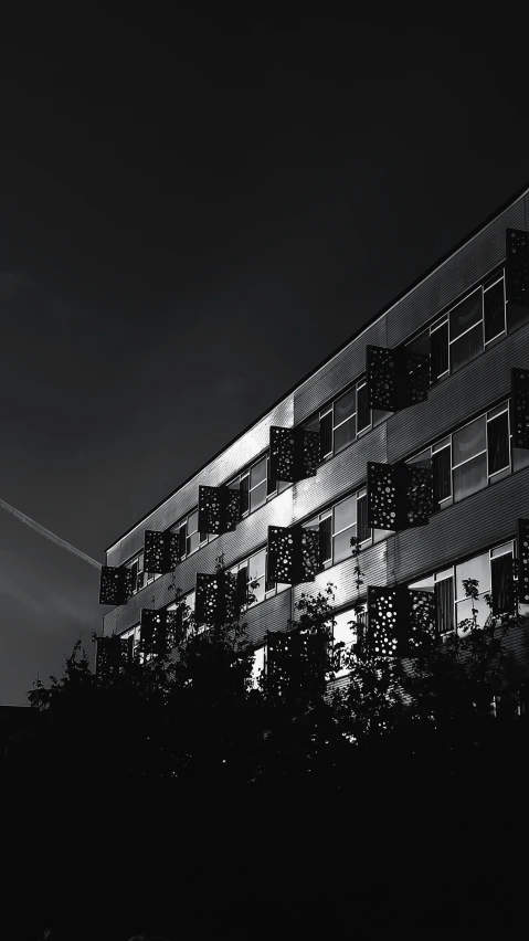 a building is seen in the dark with a clock tower in the background