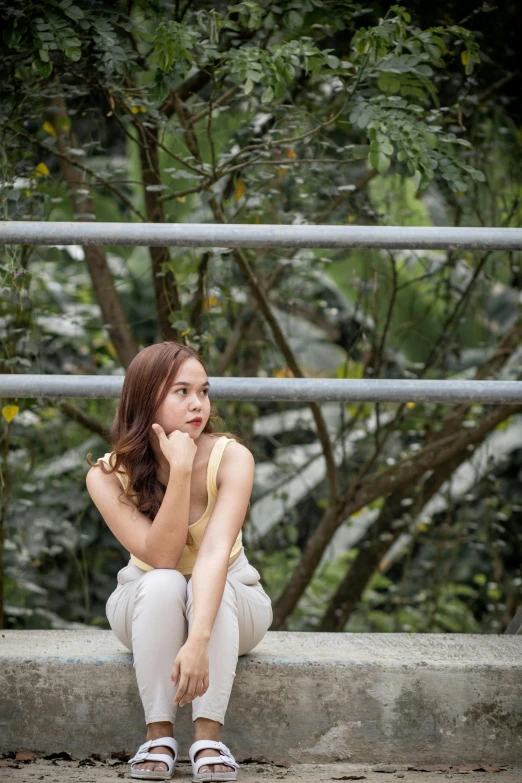 the woman is sitting on a stone step posing for a picture