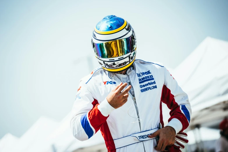 a racer is standing in front of a tent while wearing a helmet